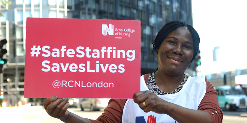 An RCN member holding a sign that says Safe staffing saves lives