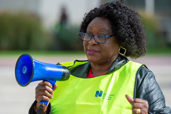 A nurse on strike holding a megaphone