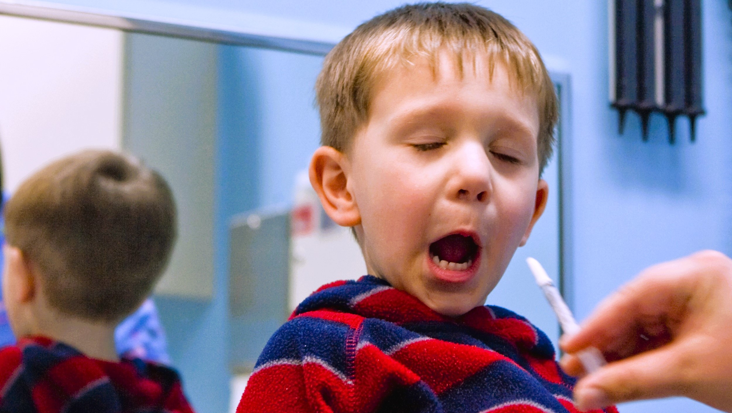 A young boy getting his nasal flu vaccination