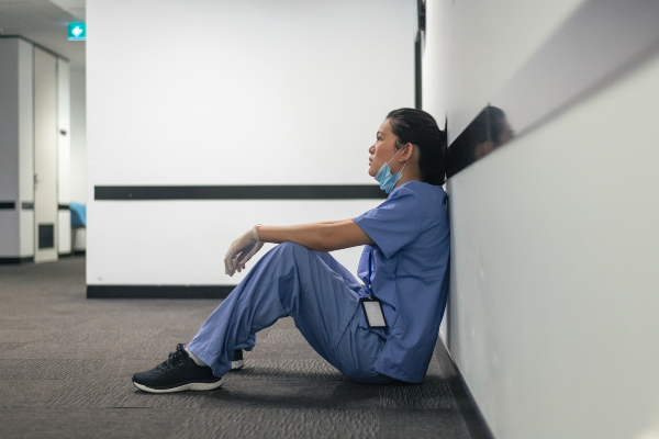 Image of exhausted nurse sitting in the corridor