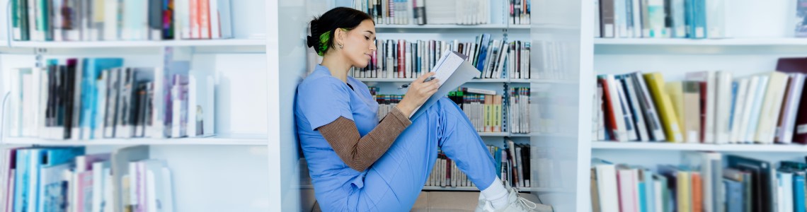 Nurse in library reading books