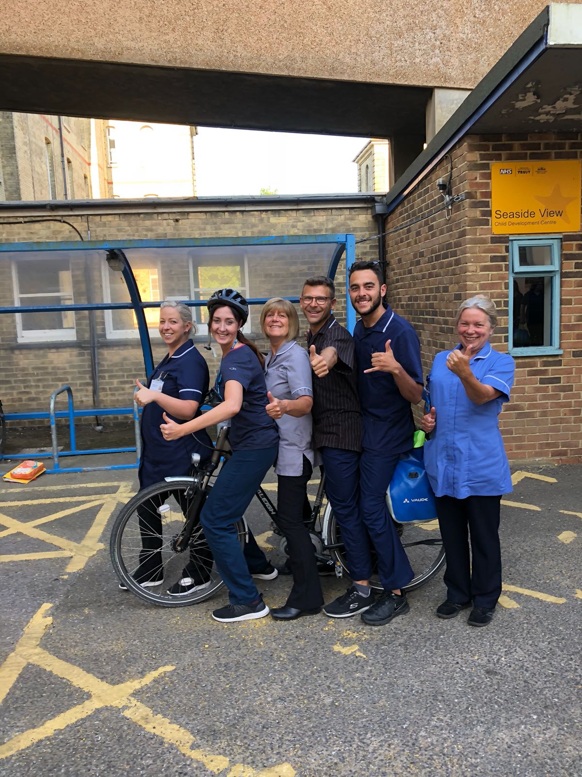 photo of a group of nurses smiling with a bike