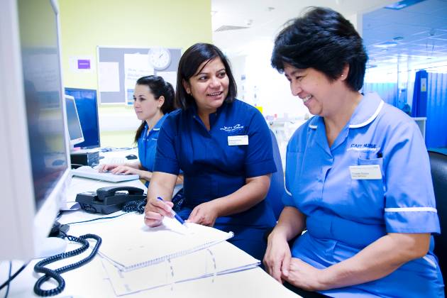 Nursing staff talking sat at desk